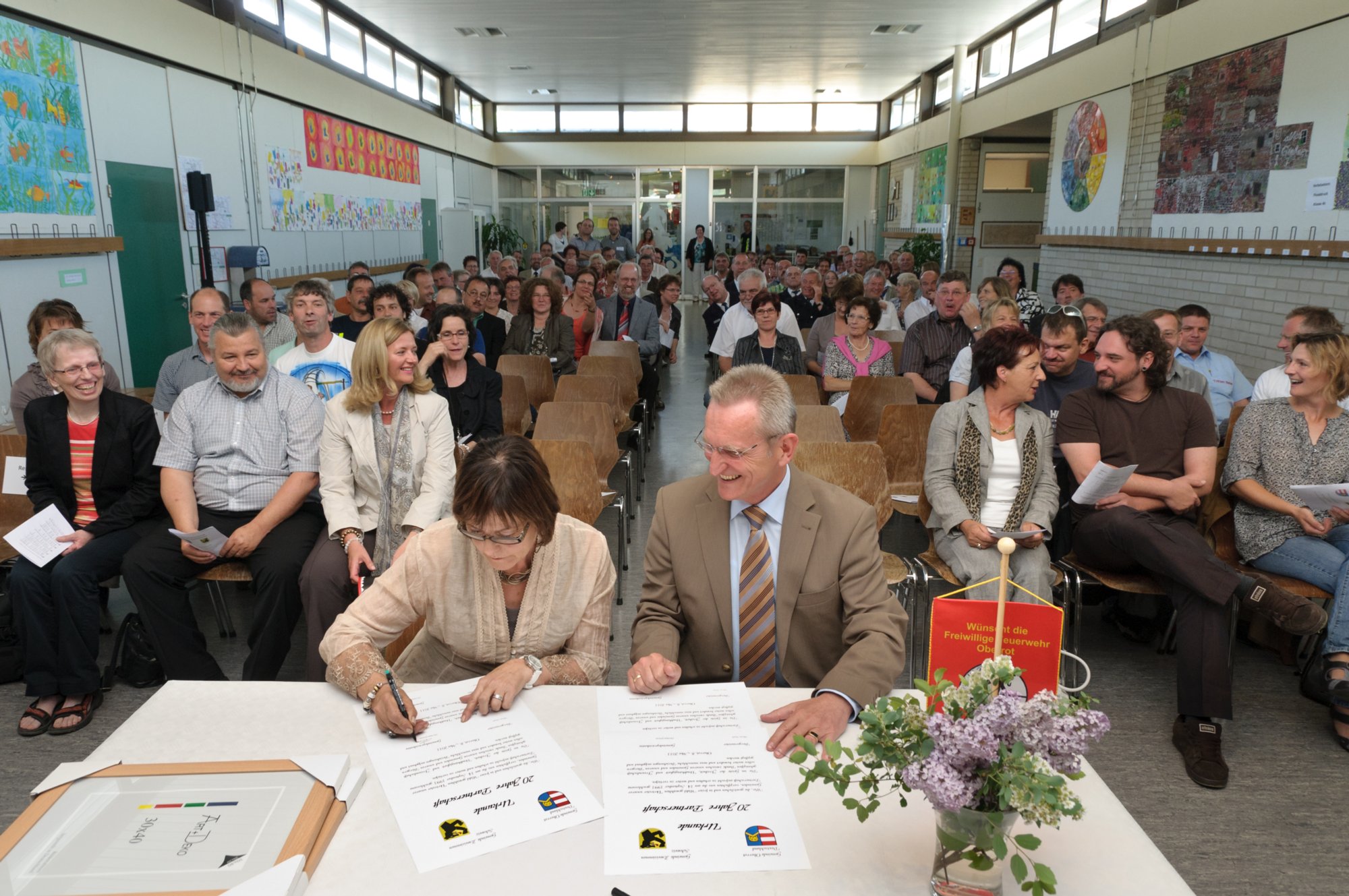 Feier zum 20jährigen Bestehen der Partnerschaft Zweisimmen - Ob In einem feierlichen Akt in der Aula der Grund- und Hauptschule Oberrot unterschrieben Gemeindepräsidentin Christiane Griessen (links) und Bürgermeister Strack (rechts) die Urkunden zu „20 Jahre Partnerschaft“.