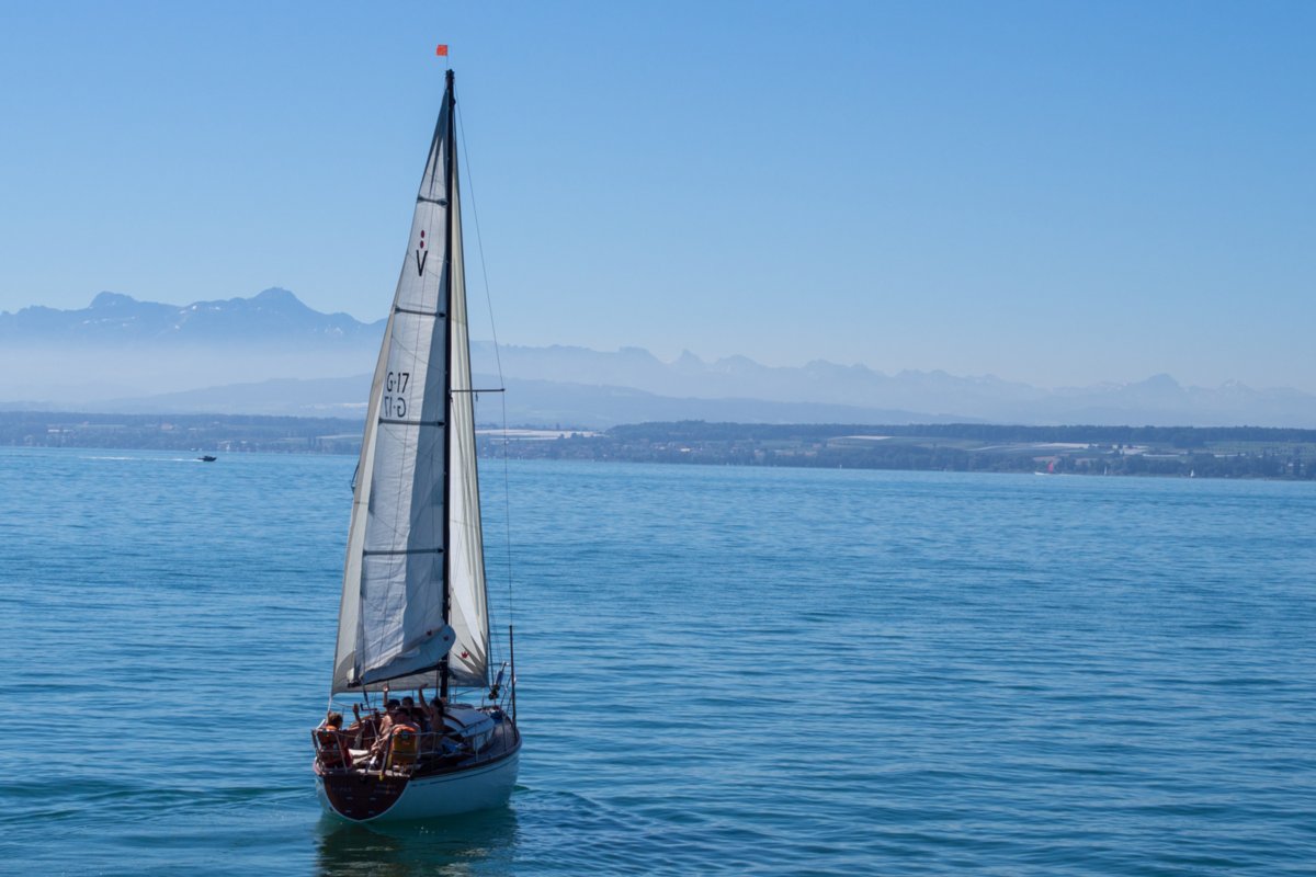 Boote und Blick zu den Bergen Bodenseeschiffahrt: Lindau, Abfahrt in Lindau , Wasserburg, Nonnenhorn, Kressbronn, Langenargen, Friedrichshafen, Immenstaad, Hagnau, Meersburg, Mainau, Einfahrt Konstanz, Stadtbummel durch Konstanz und per Schiff zurück nach Lindau.