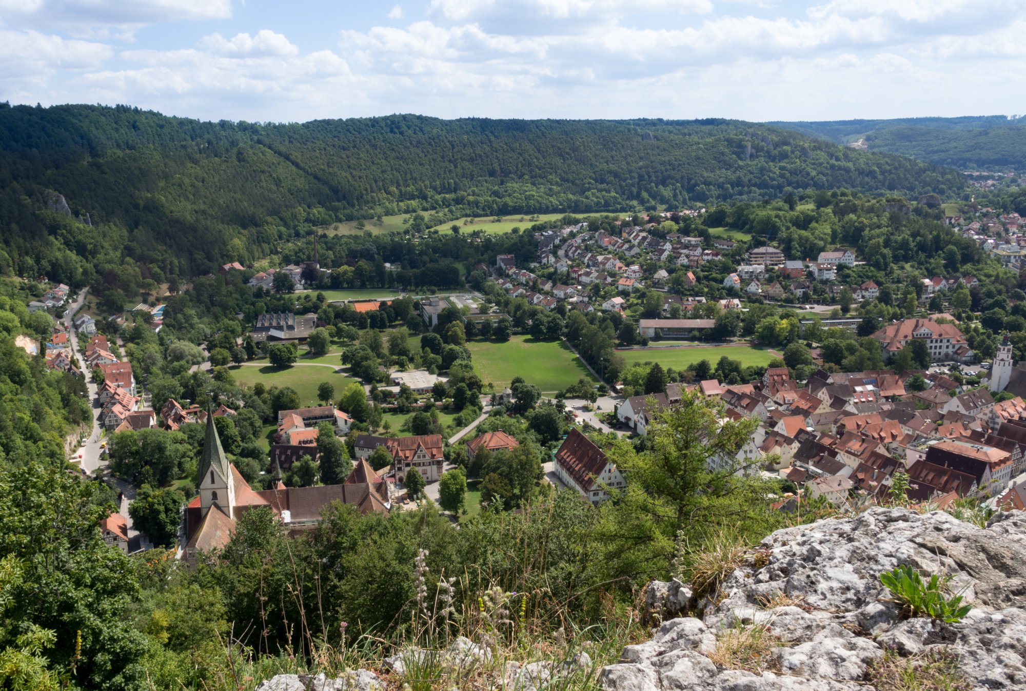 Auf dem Blaufels mit Blick nach Blaubeuren. Wanderung von Blaubeuren Bahnhof zum Rusenschloss. Von dort über den Knoblauchfelsen zum Blaufelsen. Hinunter zur B28. Diese überquerend Aufstieg auf Teerweg bis zur Steigziegelhütte, da Abzweig nach links zum Landeplatz Seißen nicht gefunden. Entlang am Waldrand zur Wegmarkierung. Dieser folgend zur Günzelburg. Von dort zum Felsenlabyrinth und zur Küssenden Sau. Abstiefg zum Bahnhof. Mit dem Auto zum Blautopf.