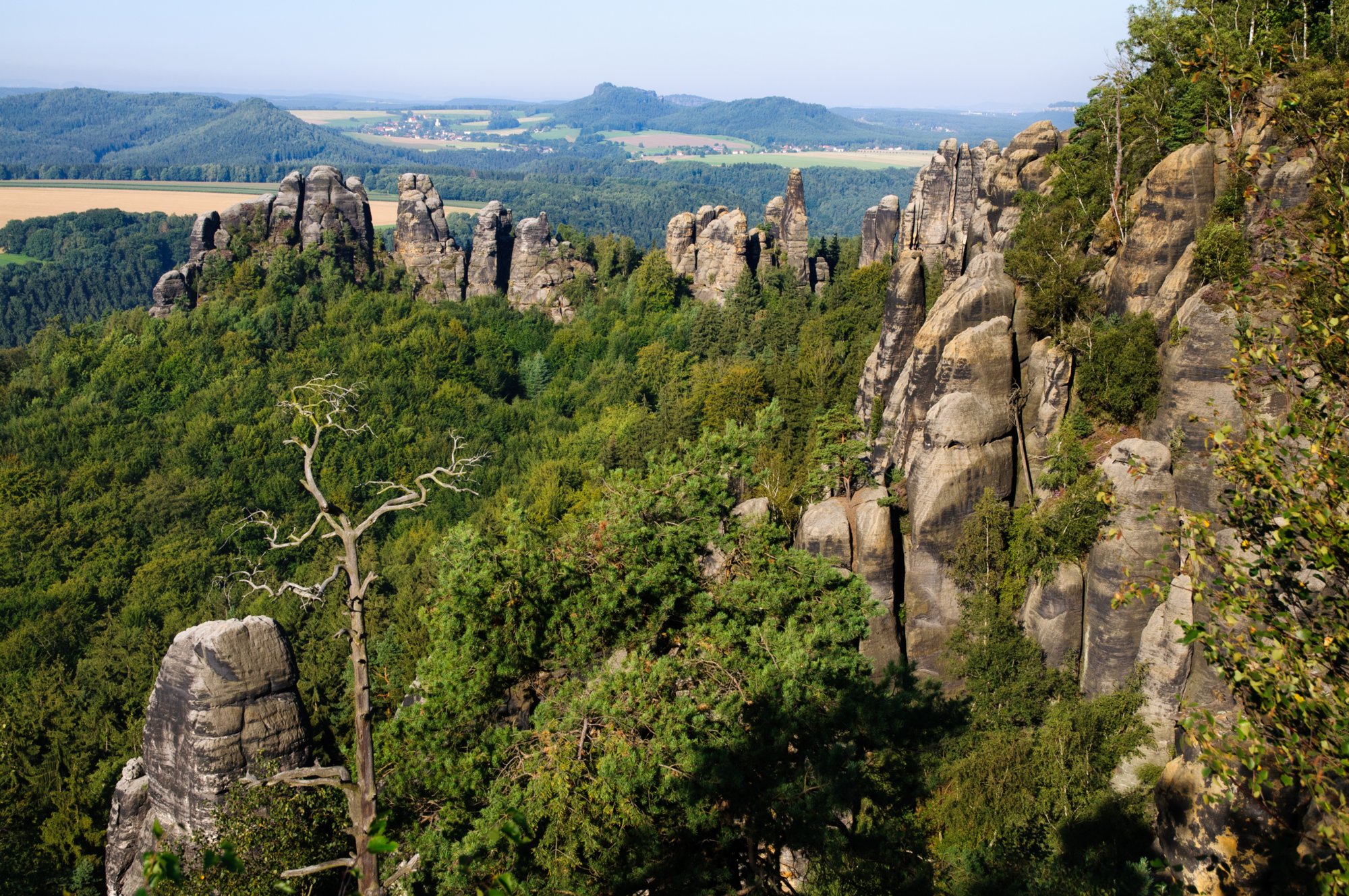 Sächsische Schweiz 2009 Wanderungvon Ostrau in die Schrammsteine und auf die Hohe Liebe. Auf dem Schrammsteingradweg. Die Schrammsteine sind eine langgestreckte, stark zerklüftete Felsgruppe des Elbsandsteingebirges, die sich östlich von Bad Schandau in der Sächsischen Schweiz befindet. Im Norden werden sie durch das Kirnitzschtal, im Süden vom Elbtal und im Osten von den Affensteinen begrenzt. Die Höhenpunkte der Kette liegen bei über 400 m ü. HN. Die Schrammsteinausssicht liegt bei 417 m ü. HN. Im Westen bildet der vordere Torstein den Anfang der Felskette im Südwesten. Die Kette zieht sich dann, durchbrochen von drei mächtige senkrechte Felsöffnungen, den sogenannten Schrammtorebis zur Schrammsteinaussicht. Hier enden die sogenannten Vorderen Schrammsteine. In Richtung Schmilka schließen sich die Hinteren Schrammsteine an. Der einzeln stehende Falkenstein mit einer Höhe von ca. 381 m und der Hohe Torstein mit 425,7 m ü. HN sind die bedeutendsten Gipfel der Schrammsteine. Die anderen Gipfel der Felsgruppe stehen fast ausschließlich am und auf dem terrassenförmigen Massiv des Schrammsteingrates. Die Schrammsteine sind ein vielbesuchtes Touristenziel; besonders die plateauartigen Aussichten und der Gratweg erfreuen sich großer Beliebtheit. Sowohl Wanderer als auch Bergsteiger finden hier ein komplexes Felsenmassiv, das sich durch eine Vielzahl unterschiedlich schwieriger Wanderwege bzw. Kletterfelsen auszeichnet. Quelle: http://de.wikipedia.org/wiki/Schrammsteine