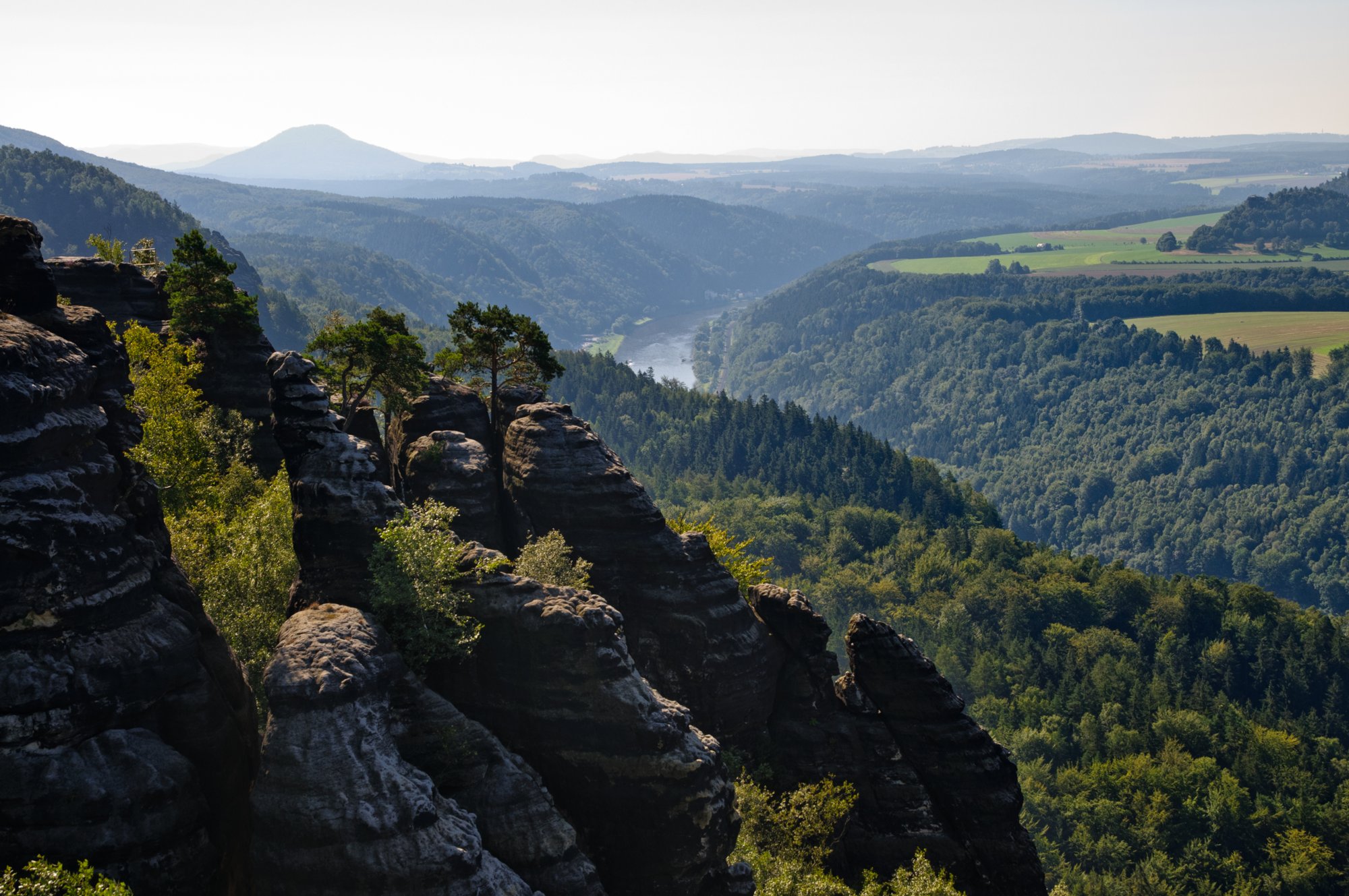 Sächsische Schweiz 2009 Wanderungvon Ostrau in die Schrammsteine und auf die Hohe Liebe. Schrammsteinaussichten. Blick ins Elbtal Richtung Tschechien. Die Schrammsteine sind eine langgestreckte, stark zerklüftete Felsgruppe des Elbsandsteingebirges, die sich östlich von Bad Schandau in der Sächsischen Schweiz befindet. Im Norden werden sie durch das Kirnitzschtal, im Süden vom Elbtal und im Osten von den Affensteinen begrenzt. Die Höhenpunkte der Kette liegen bei über 400 m ü. HN. Die Schrammsteinausssicht liegt bei 417 m ü. HN. Im Westen bildet der vordere Torstein den Anfang der Felskette im Südwesten. Die Kette zieht sich dann, durchbrochen von drei mächtige senkrechte Felsöffnungen, den sogenannten Schrammtorebis zur Schrammsteinaussicht. Hier enden die sogenannten Vorderen Schrammsteine. In Richtung Schmilka schließen sich die Hinteren Schrammsteine an. Der einzeln stehende Falkenstein mit einer Höhe von ca. 381 m und der Hohe Torstein mit 425,7 m ü. HN sind die bedeutendsten Gipfel der Schrammsteine. Die anderen Gipfel der Felsgruppe stehen fast ausschließlich am und auf dem terrassenförmigen Massiv des Schrammsteingrates. Die Schrammsteine sind ein vielbesuchtes Touristenziel; besonders die plateauartigen Aussichten und der Gratweg erfreuen sich großer Beliebtheit. Sowohl Wanderer als auch Bergsteiger finden hier ein komplexes Felsenmassiv, das sich durch eine Vielzahl unterschiedlich schwieriger Wanderwege bzw. Kletterfelsen auszeichnet. Quelle: http://de.wikipedia.org/wiki/Schrammsteine