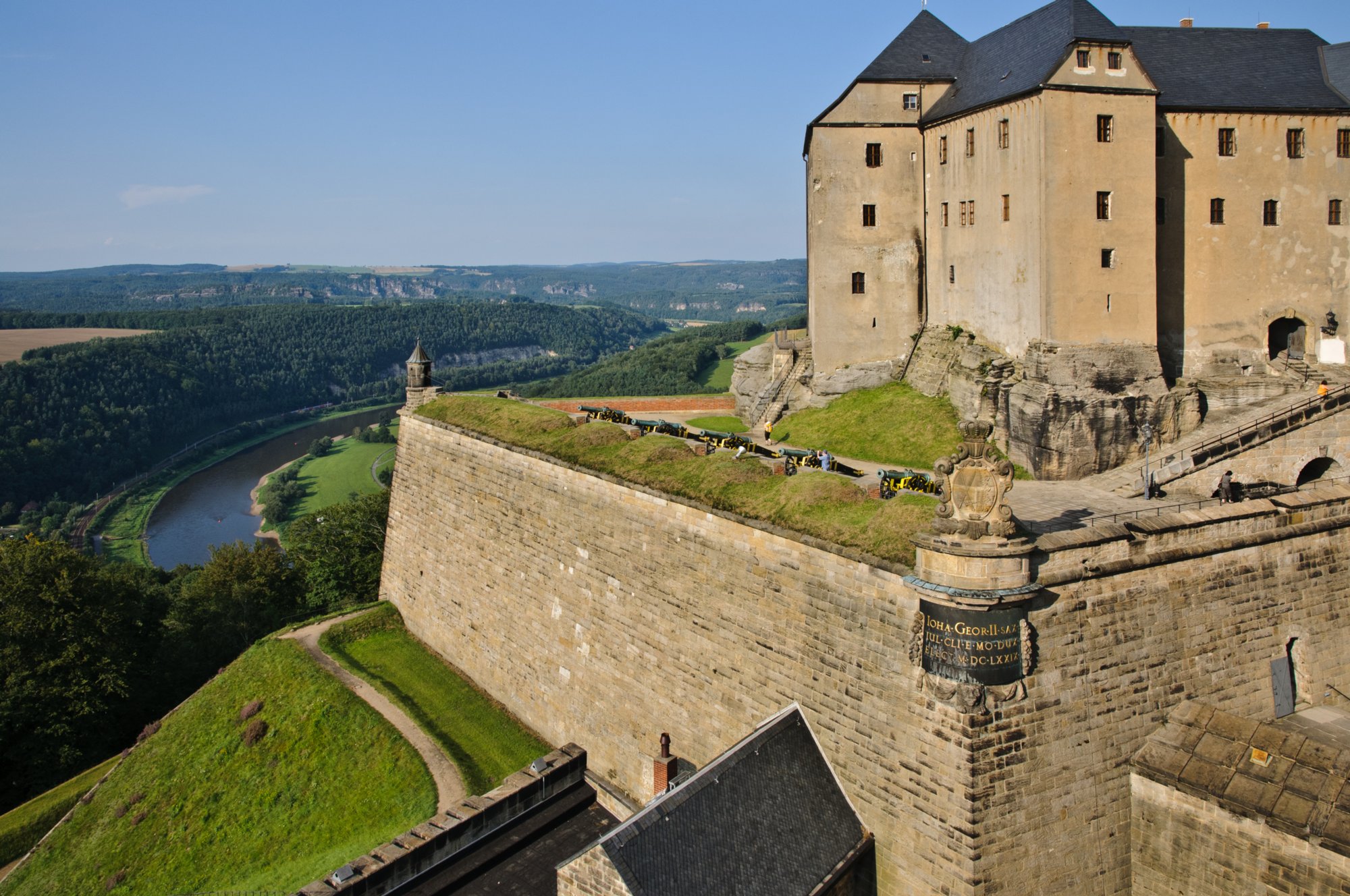 Sächsische Schweiz 2009 Die Festung Königstein ist eine der größten Bergfestungen in Europa und liegt inmitten des Elbsandsteingebirges auf dem gleichnamigen Tafelberg oberhalb des Ortes Königstein am linken Ufer der Elbe im Landkreis Sächsische Schweiz-Osterzgebirge (Sachsen). Das 9,5 Hektar große Felsplateau erhebt sich 240 Meter über die Elbe und zeugt mit über 50 teilweise 400 Jahre alten Bauten vom militärischen und zivilen Leben auf der Festung. Der Wallgang der Festung ist 1.800 Meter lang und hat bis zu 42 Meter hohe Mauern und Sandstein-Steilwände. Im Zentrum der Anlage befindet sich der mit 152,5 Meter tiefste Brunnen Sachsens und zweittiefste Brunnen Europas. Quelle: http://de.wikipedia.org/wiki/Festung_Königstein