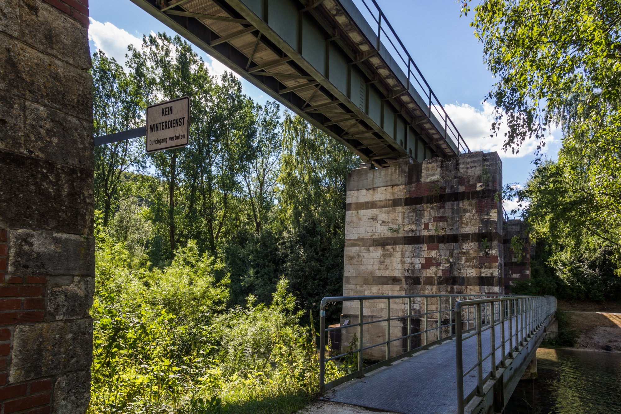 Eisenbahnbrücke an der Blau Zugfahrt von Blaustein nach Herrlingen. Wanderung vom Bahnhof Herrlingen über das Rommel-Denkmal und Wippingen zum Rusenschloss oberhalb von Blaubeuren. Von dort Abstieg zum Bahnhof Blaubeuren und Rückfahrt mit dem Zug nach Blaustein.